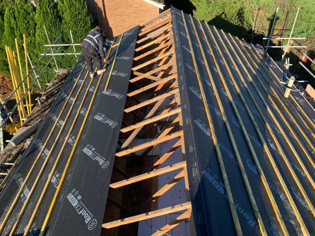 roofer applying underlay on a new roof